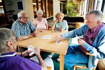 Image showing a group of older men and women enjoying a game of cards